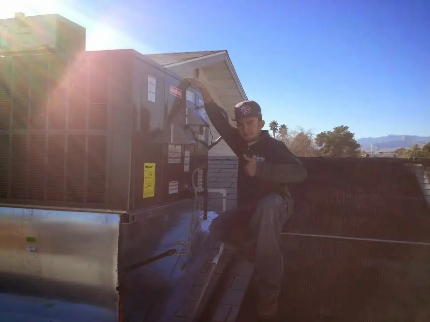 HVAC technician performing HVAC Inspection on a rooftop unit in Godley